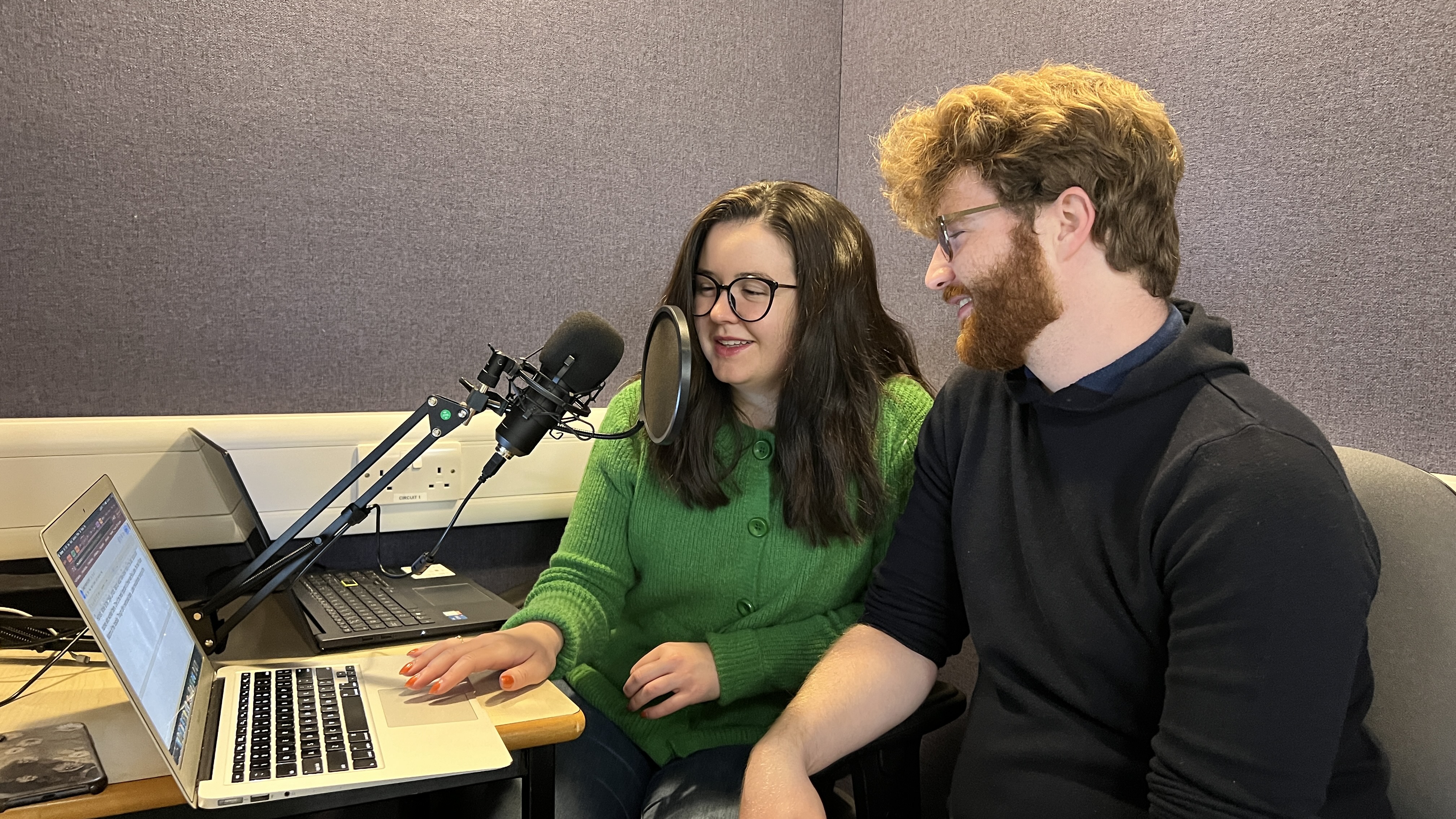 Students recording a podcast with a mic