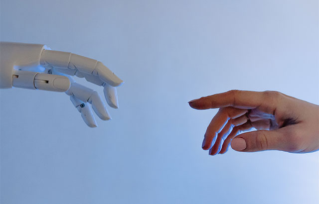A robotic hand reaching towards a human hand.