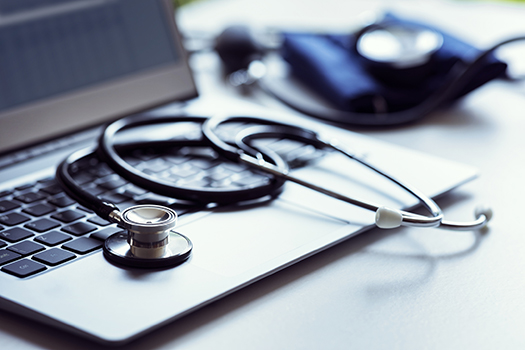 A GP's computer and stethoscope