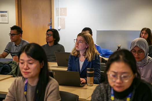 Queen Mary LLM students sat in class with laptops at the Centre for Commercial Law Studies.