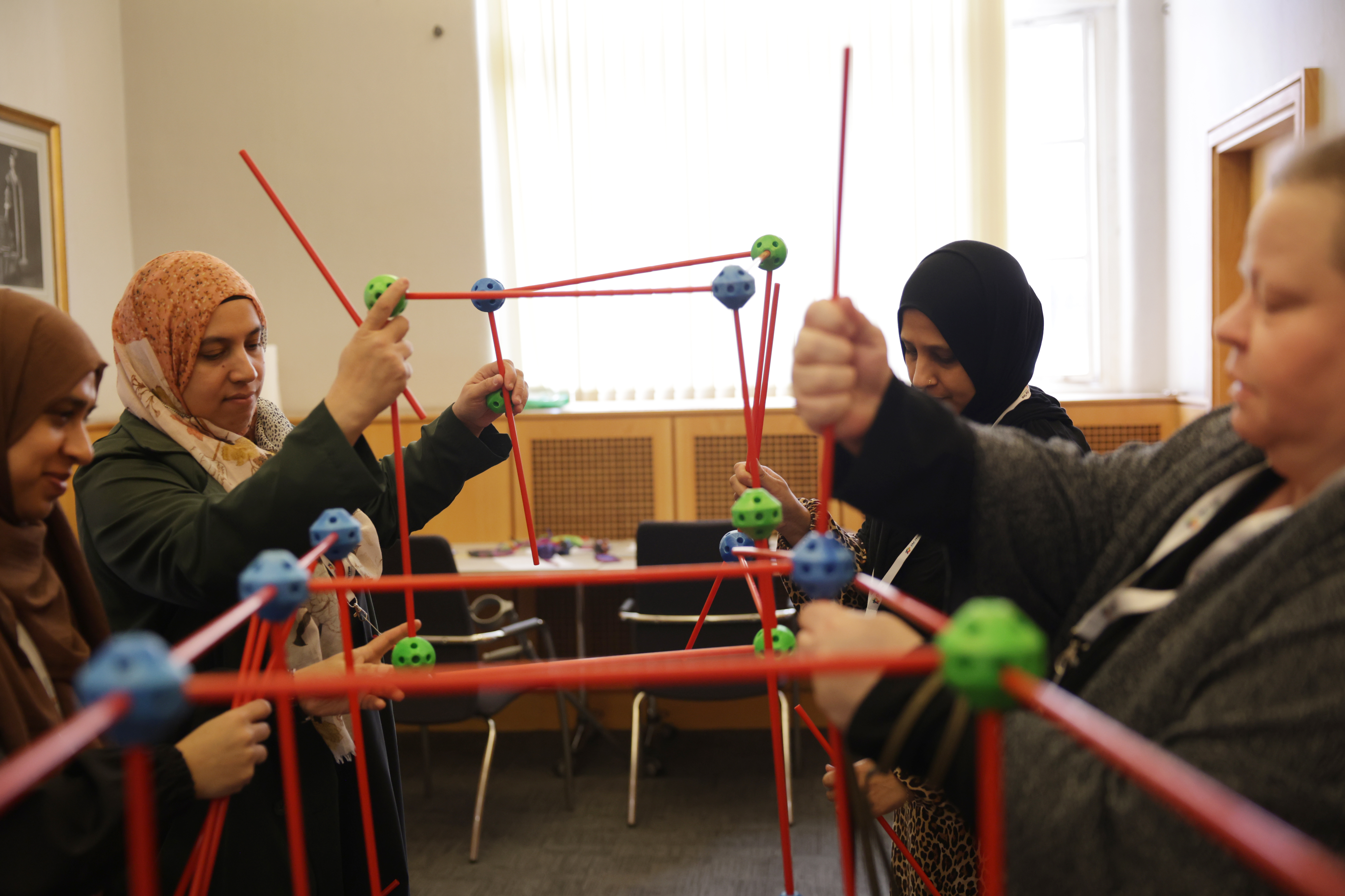 Women create a structure with sticks as part of the SEND area at the QMUL Moon Palace STEAM activity fair