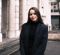 Justine Porcario stood on a street in front of some columns.