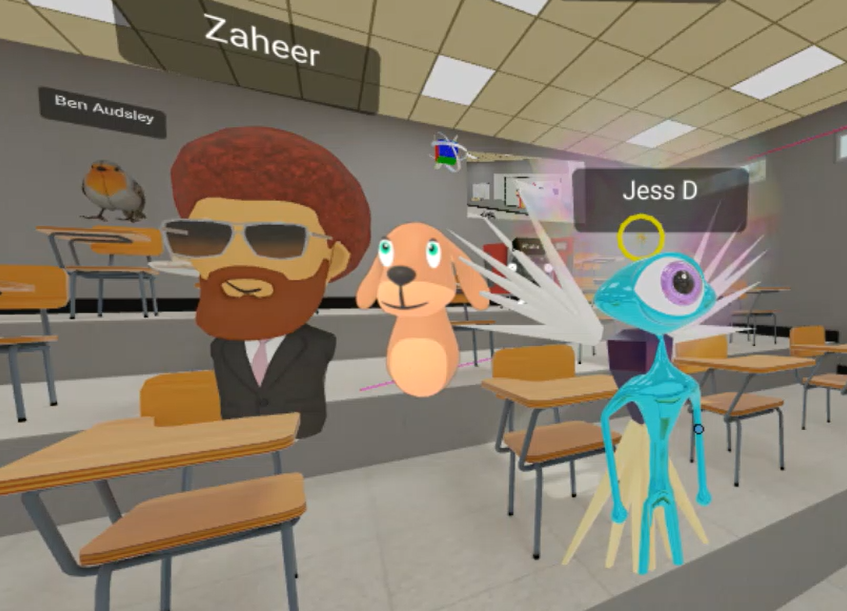 Mozilla hubs appears to be inside a room within a virtual world. There are desks and a range of avatars. Possibly a canteen.